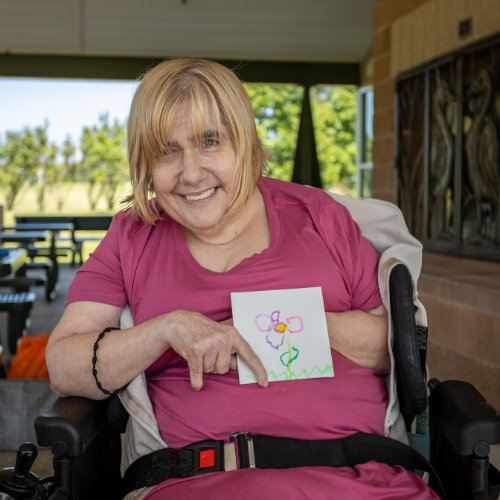 Amie smiling with her artwork at the ambassador photo shoot! 