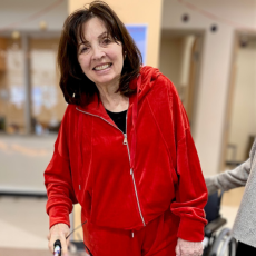 a woman in red, indoors, smiling for the camera. 