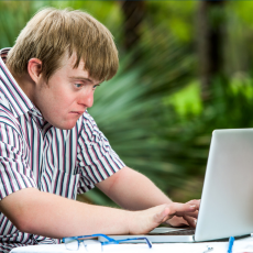 a man sitting and typing on a laptop