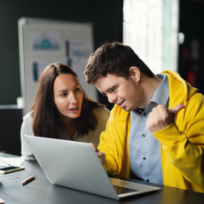 a young man and woman working on a computer