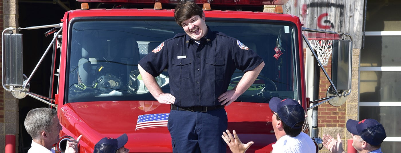 Cody standing on top of a firetruck