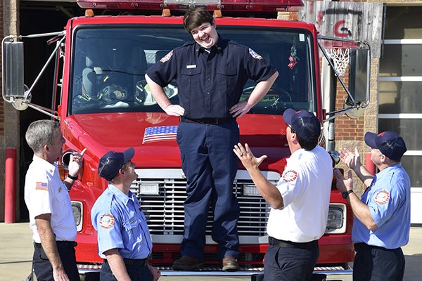 Cody standing on top of a firetruck