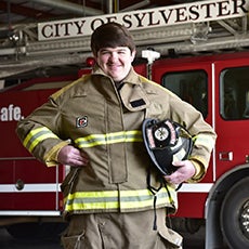 Cody standing next to firetruck