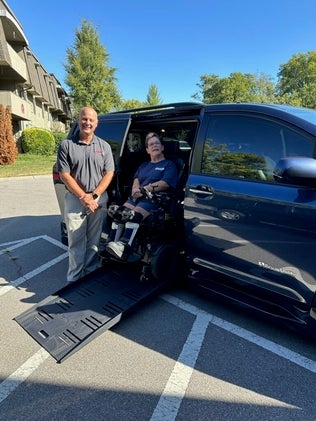 Rhonda on the lift into her van with her driver 