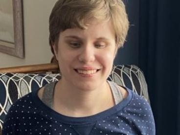 Alicia Krage headshot. Alicia a white woman smile at the camera. She has short brunette hair. 