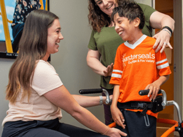 Jaxon with Easterseals staff, using a walker