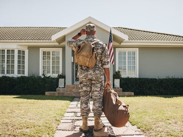 Veteran standing in front of house