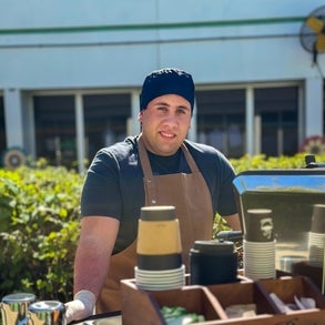 Leandro standing by his coffee cart