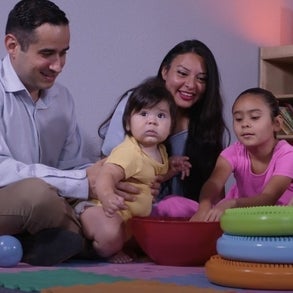 Mother and father on the floor playing with their children