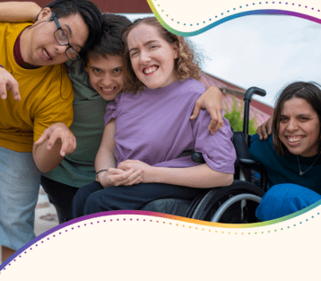 A group of teens and young adults with disabilities smiling playfully