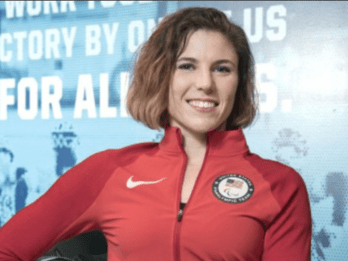 Amanda McGrory in a red athletic jumpsuit and an American pin