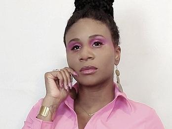Lachi in a pink shirt, wearing matching make up.