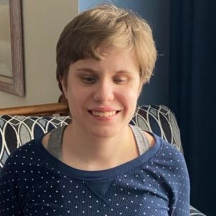 Alicia Krage headshot. Alicia a white woman smile at the camera. She has short brunette hair. 