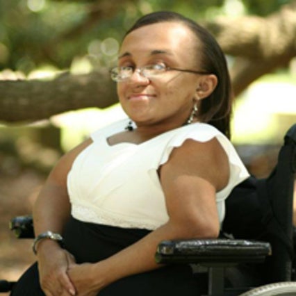 Vilissa, a black woman, sitting in her wheelchair wearing a black and white dress