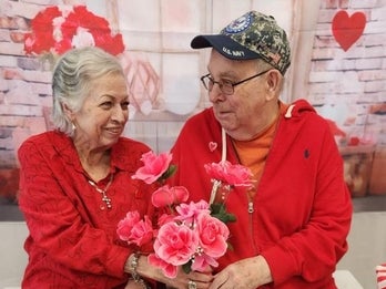 two seniors share flowers at a Valentine's Day event