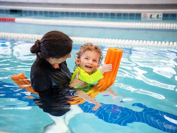 young boy gets physical therapy in a pool