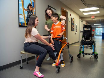 young boy receiving physical therapy outside the home