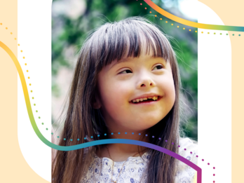 A young child with Down syndrome smiles