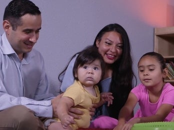 Mother and father on the floor playing with their children
