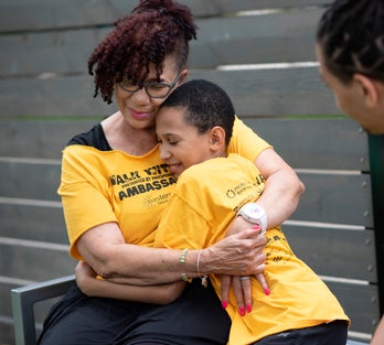walkathon fundraiser at which adult and child hug