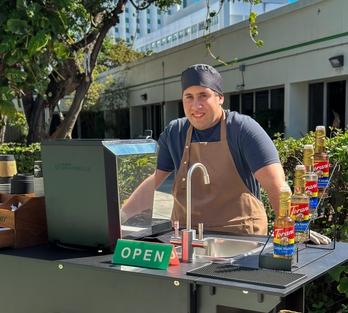 Leandro standing by his coffee cart