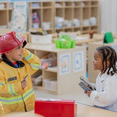 Boy in firefighter uniform with girl in doctor uniform