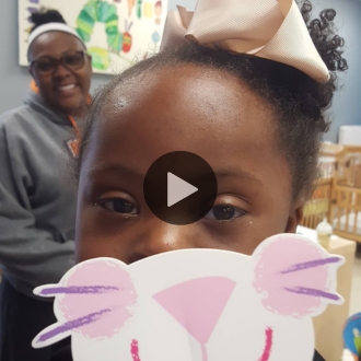Cleilia smiling behind cat puppet